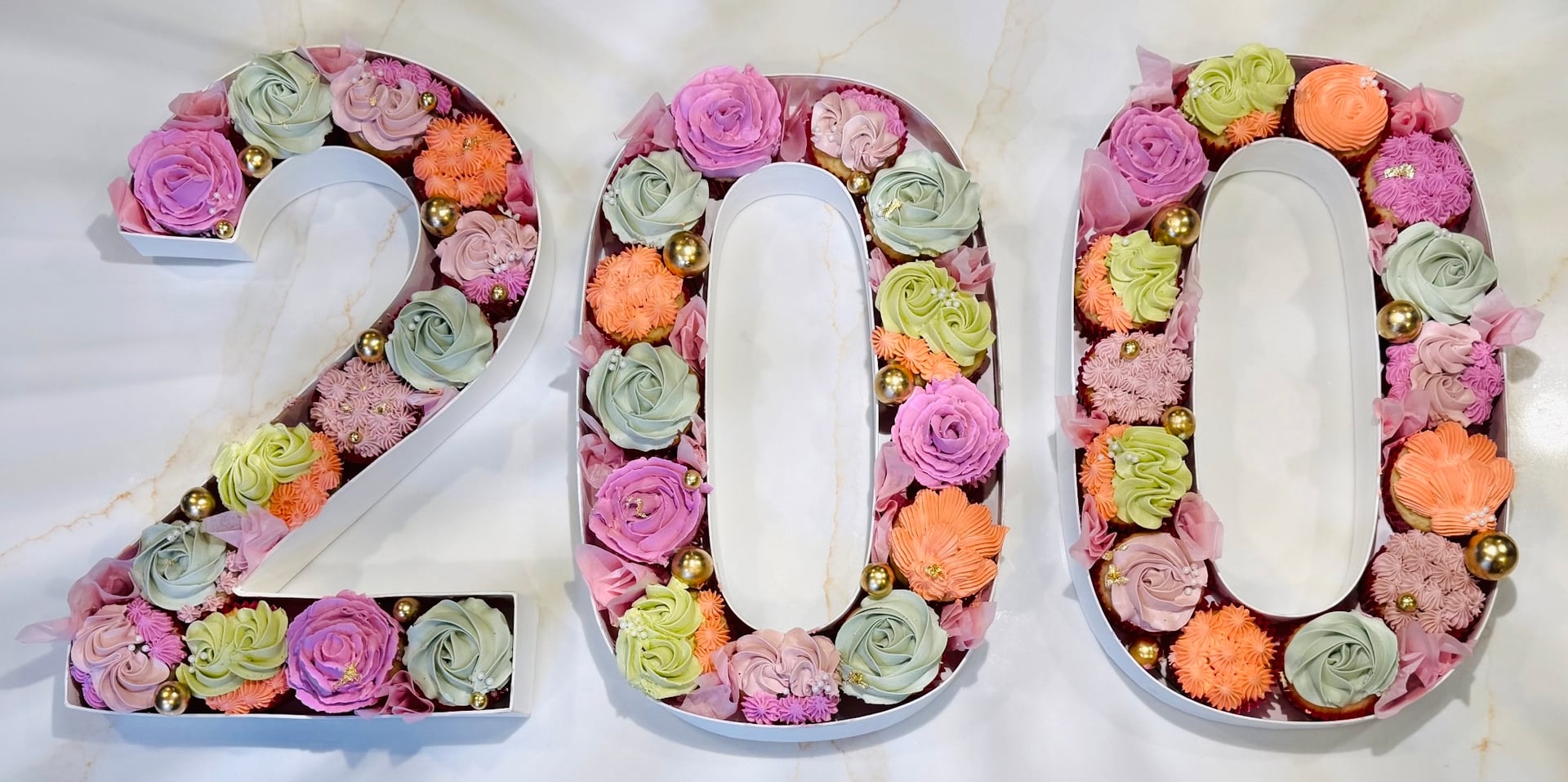 Number 200 cupcake arrangement with pastel buttercream florals and gold accents